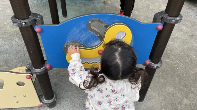 豊砂公園の回転する装置を回す娘の写真