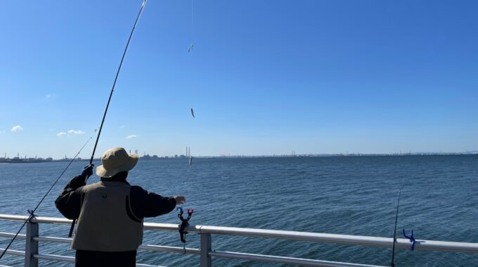 検見川浜突堤でイワシを釣っている人の写真